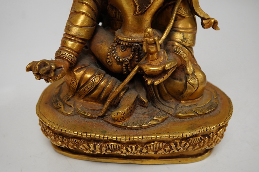 A Tibetan gilt bronze figure of a deity and consort, 15cm high. Condition - good